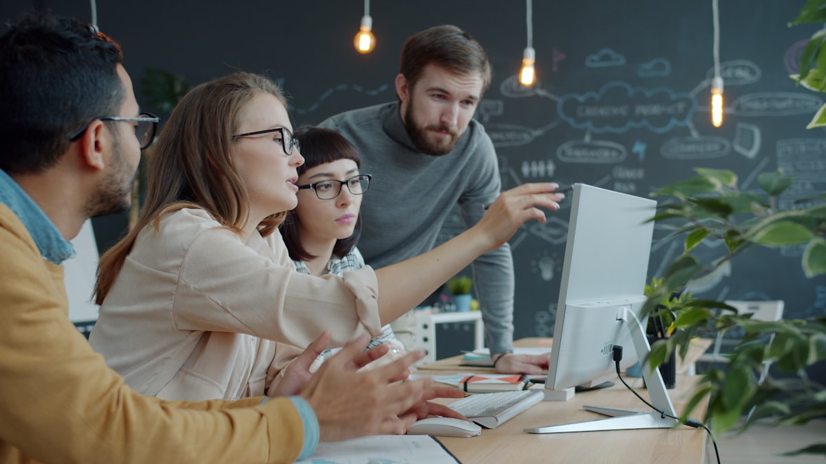 A small team collaborating around a computer